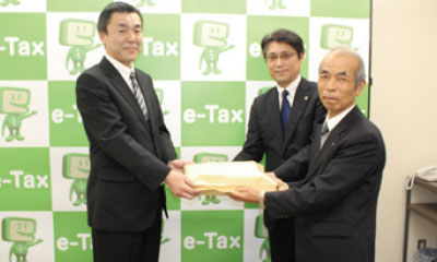 税理士と税務申告書の提出をする関根組合長